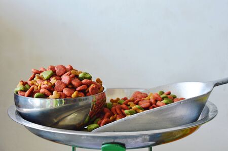 dog food in stainless bowl and iron scoop on weighing scaleの写真素材