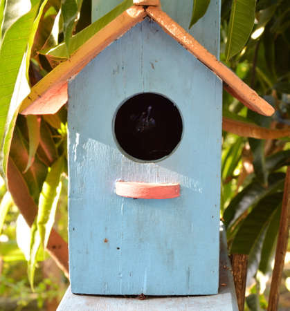 blue wooden bird house in the gardenの写真素材