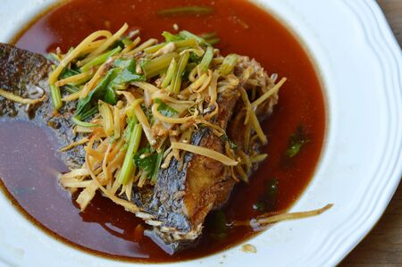 deep fried Nile tilapia dressing soy sauce and slice ginger