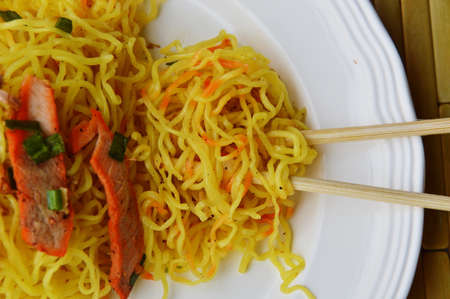 Chinese noodle with barbecue pork picking by wooden chopstick