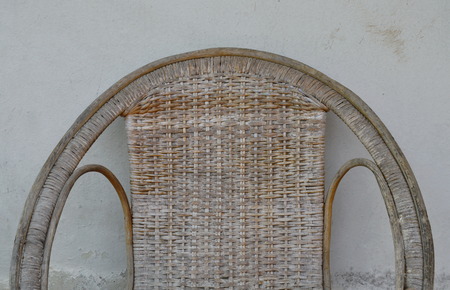 old rattan chair on white wallの写真素材