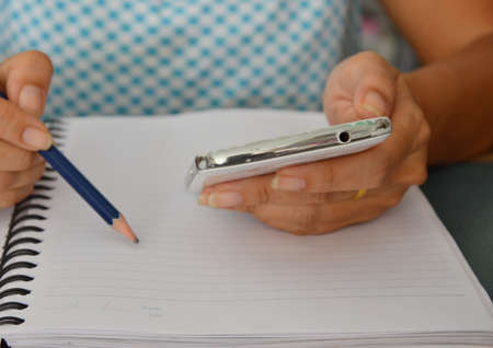 people note information on book from cellphoneの写真素材