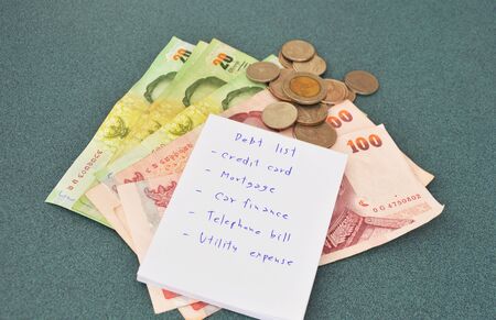 debt list and Thai money on table