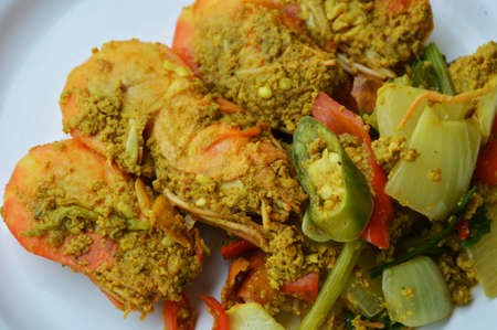 spicy stir-fried prawn with yellow curry on dishの写真素材