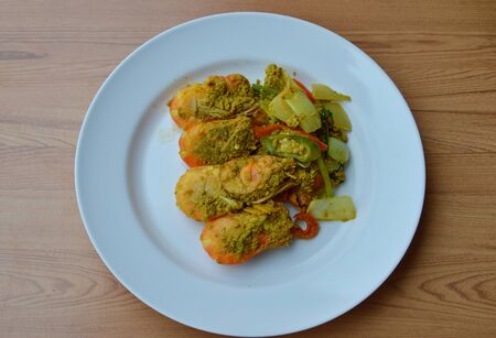 spicy stir-fried shrimp with yellow curry on plateの写真素材