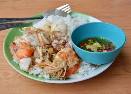 fried shrimp and squid with garlic on riceの写真素材