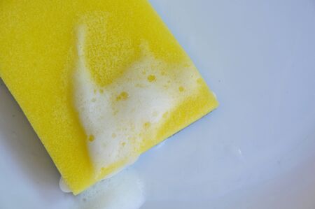 yellow scrub sponge wash on white plate