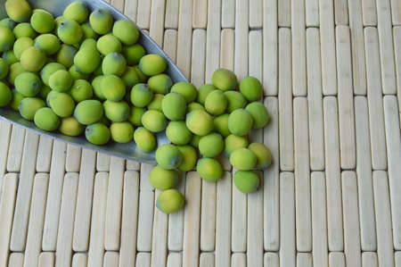 lotus seed in iron scoop on bamboo plateの写真素材