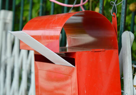 letter in red post box on home fence