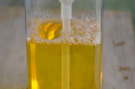 yellow dish washing soap bubble in square bottle