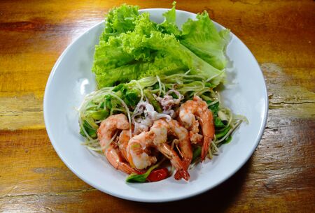 sunflower sprout with shrimp and squid spicy salad on dishの写真素材