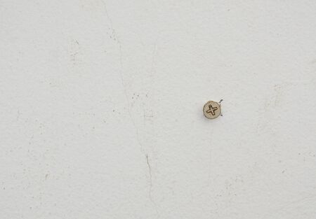 nut screw drill on white cement wall for mobile some objectの写真素材