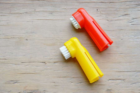 pet toothbrush used by put in finger on wooden boardの写真素材