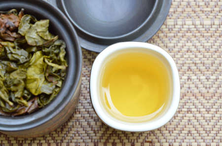 tea cup and leaf in jar on bamboo matの写真素材