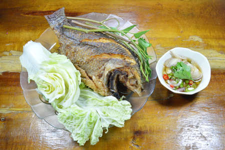 deep fried mango fish dipping chili fish sauce and vegetable on dish