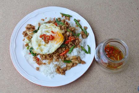 spicy stir fried minced pork with basil leaf topping egg on riceの写真素材