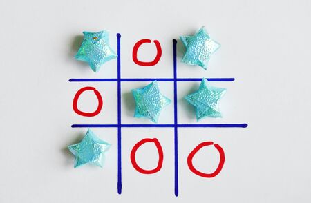 color star paper in tic-tac-toe board game on white paper