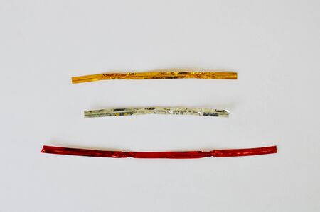 golden silver and bronze twist tie on white background