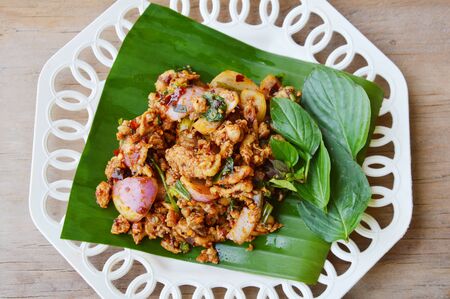 spicy minced chicken salad on banana leafの写真素材