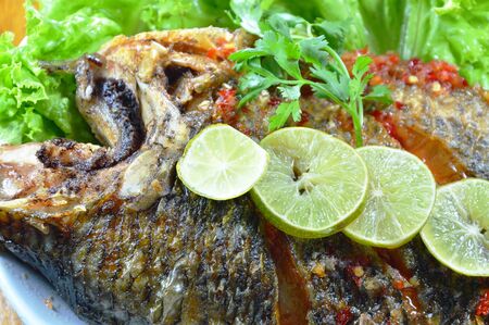 deep fried mango fish dressing sweet chili sauce and slice lemon