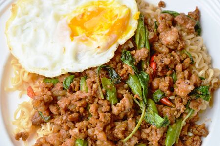 instant noodle topping spicy stir fried chop pork and basil leaf with eggの写真素材