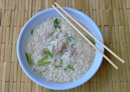 boiled rice with minced pork and wooden chopstick on bowl