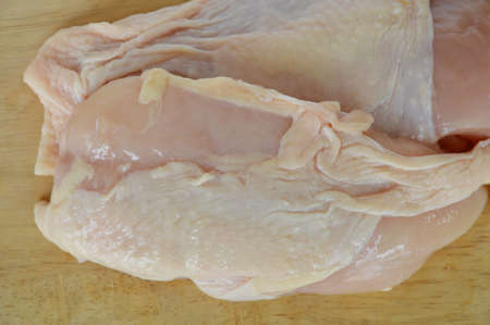 raw chicken on wooden chop plateの写真素材