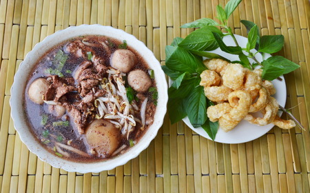 boiled pork ball in brown soup and basil leaf