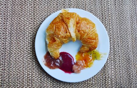 butter croissant and assorted jam on dishの写真素材