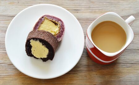 chocolate and grape jam roll filled cream eat couple with coffee in red cupの写真素材