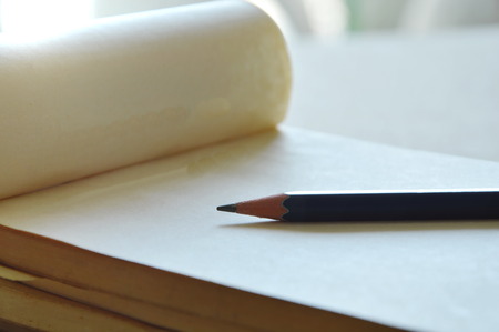 pencil on white paper notebook on deskの写真素材