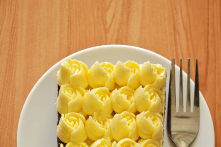 cream decorate rose flower topping chocolate and fork on dishの写真素材
