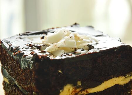 chocolate butter cake topping slicing white chocolate on wooden chop plate