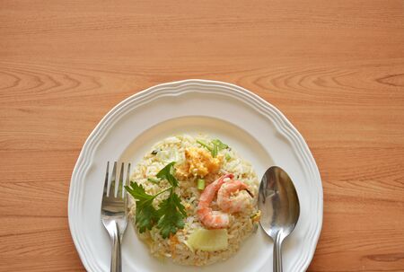 fried rice egg topping shrimp with spoon and fork on plateの写真素材
