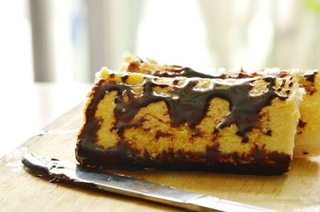 bread with butter dressing chocolate sauce on wooden chop block