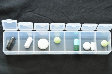 medicine and capsule in plastic cartridges on black clothの写真素材