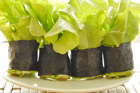 green oak and sausage wrapped by seaweed on plateの写真素材