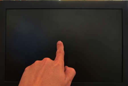 human finger touching on black computer screen