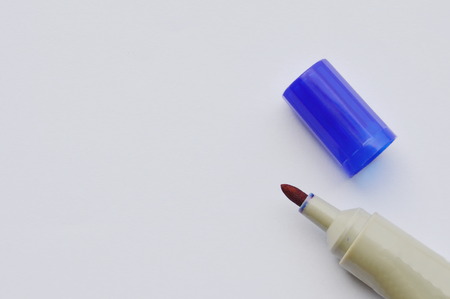 blue permanent marker pen and cover on white paperの写真素材