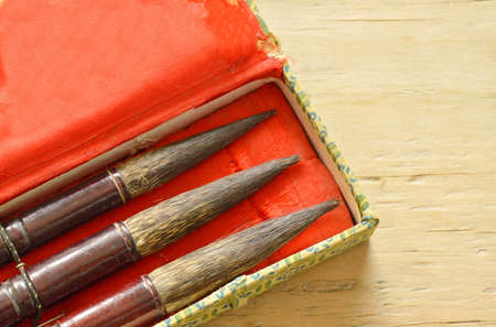 Chinese calligraphy variety size in box on wooden tableの写真素材