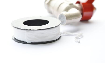 iron water tap spare parts and roll sealed tape on white backgroundの写真素材
