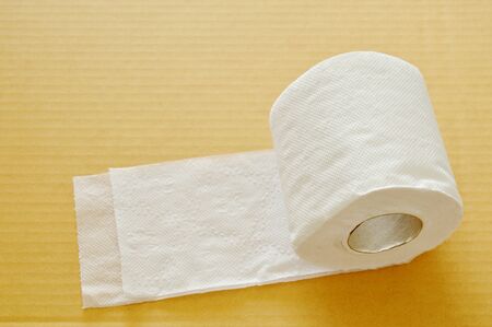 white tissue paper rolling on brown hard sheet boardの写真素材