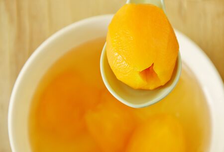 plum mango tropical fruit in syrup with ice cold dessert on spoonの写真素材