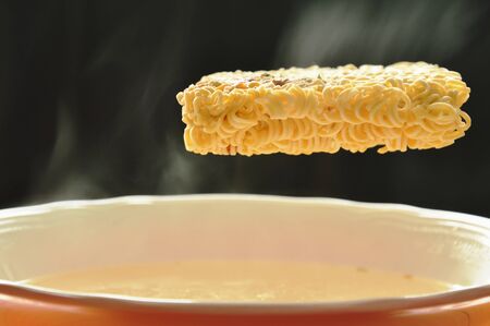instant noodles dropping to hot water with smoked on bowl