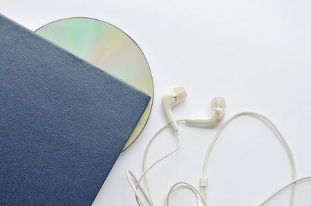 book and CD- rom with earphones on white backgroundの写真素材