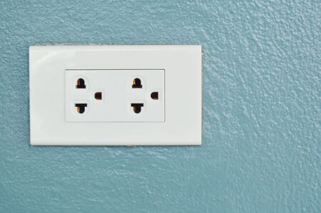 white electric power outlet on home cement wall