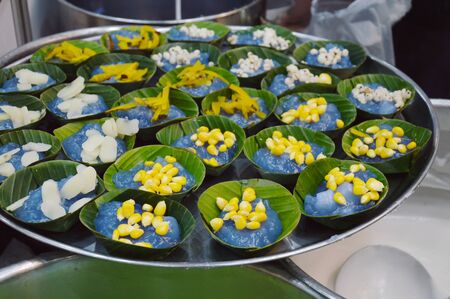 taro corn palm pumpkin and millet prepare for stuffed in pudding with coconut topping on banana leafの写真素材