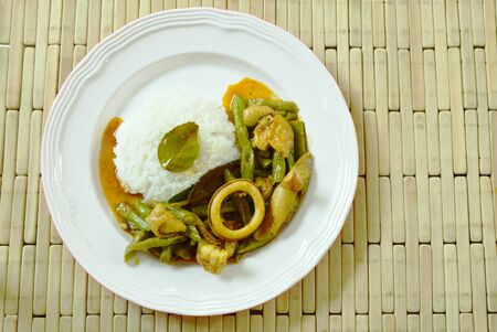 spicy stir fried squid and chicken with yard long bean in curry on riceの写真素材