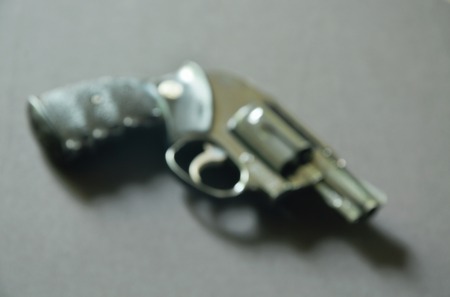 blurry revolver gun on black background