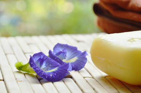 soap and towel with butterfly pea violet flower on bamboo matの写真素材